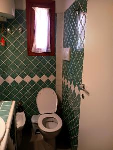 a bathroom with a toilet and a sink and a window at Appartamento Salina Bamba in San Teodoro