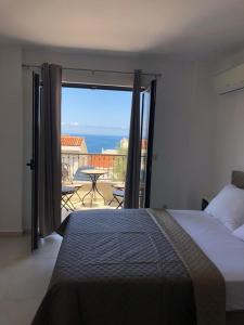 a bedroom with a bed and a view of the ocean at Apartman Bonaca in Pržno
