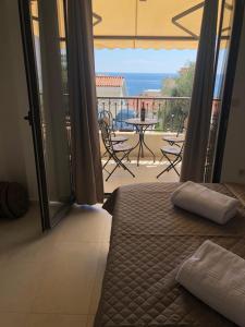 a bedroom with a bed and a balcony with a table and chairs at Apartman Bonaca in Pržno +16 photos