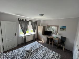 a bedroom with a bed and a desk and a window at Stokrotka in Władysławowo