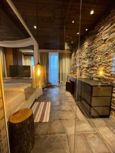 a large room with a stone wall and a desk at Vlasinsko jezero VILA BEST in Surdulica
