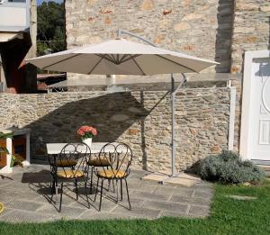 un tavolo con due sedie e un ombrellone di Antica casa nel borgo a Pietrasanta