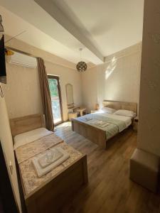 a bedroom with two beds and a table at Hotel Traveler in Kutaisi