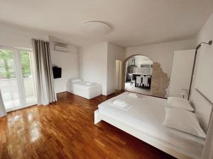 a white room with a bed and a mirror at Apartments Buljanovic in Pag