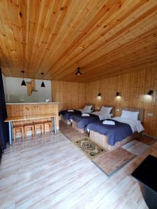 a room with four beds and a wooden ceiling at Cozy cabine in Stepantsminda