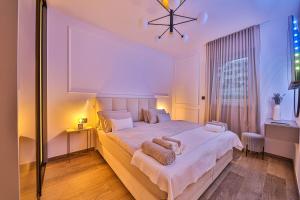 OLIVETUM luxury apartment في سبليت: غرفة نوم بسرير ابيض كبير ونافذة