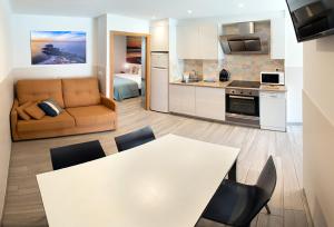 Il comprend une cuisine et un salon avec une table et des chaises. dans l'établissement Apartamentos Lurralde, à Zarautz