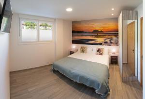 - une chambre avec un lit orné d'une peinture murale dans l'établissement Apartamentos Lurralde, à Zarautz
