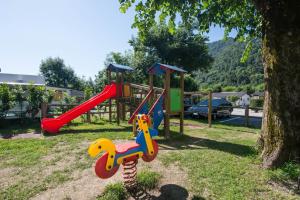 een speeltuin met een glijbaan in een park bij Mobilhome Camping Azzurro in Ledro