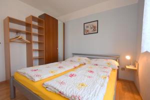 Un pequeño dormitorio con una cama con flores. en Apartments Frane, en Vantačići