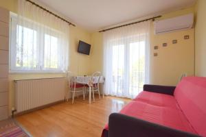 sala de estar con sofá rojo y mesa en Apartments Frane, en Vantačići