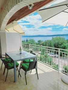a patio with a table and chairs on a balcony at Apartment Lucija in Dramalj