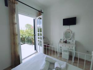 a bedroom with a bed and a tv and a mirror at Corfu countryside apartment in Potamós