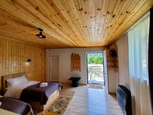 a bedroom with a bed and a tv and a wooden ceiling at Cozy cabine in Stepantsminda