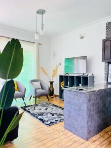 sala de estar con cocina con encimera y sofá en Apartment unit-White house with Two bedrooms en Bulindo