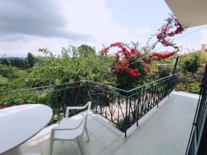 uma varanda com mesa, cadeiras e flores em Corfu countryside apartment em Potamós