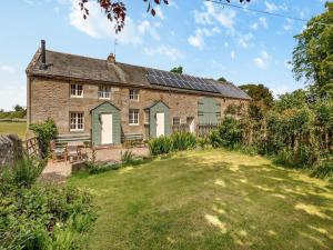 an old stone house with solar panels on the roof at Stable Cottage - 26032 in Wark