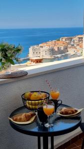 una mesa con comida y bebida en el balcón en BEAUTIFUL APARTMENT,AMAZING VIEW,parking! en Dubrovnik