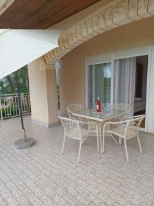 a table and chairs on a patio with an umbrella at Apartment Lucija in Dramalj