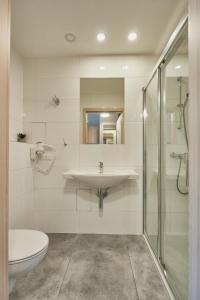 a bathroom with a sink and a shower and a toilet at Apartamenty Świnoujście - Wyspiańskiego 34e in Świnoujście