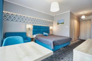 a bedroom with a blue bed and a blue chair at Apartamenty Świnoujście - Wyspiańskiego 34e in Świnoujście