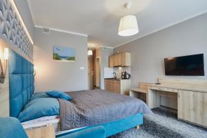a bedroom with a blue bed and a desk at Apartamenty Świnoujście - Wyspiańskiego 34e in Świnoujście