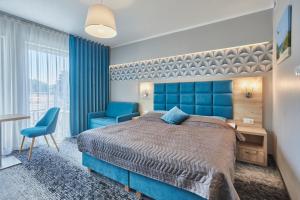 a bedroom with a blue bed and a blue chair at Apartamenty Świnoujście - Wyspiańskiego 34e in Świnoujście