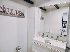 un bagno bianco con lavandino e specchio di Los Balandros 116 a San Agustin Altre 18 foto