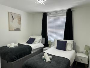 1 Schlafzimmer mit 2 Betten und einem Fenster in der Unterkunft Superb 2 bedroomed apartment in Great Oakley