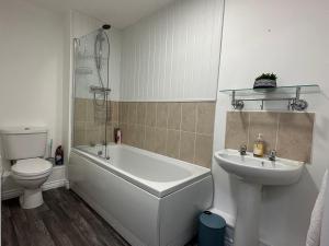a bathroom with a tub and a sink and a toilet at Superb 2 bedroomed apartment in Great Oakley