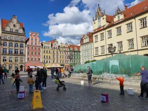 Eine Gruppe von Menschen, die in einer Stadt herumstehen in der Unterkunft Rynek pod Fredrą in Breslau
