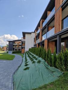 a pathway in front of a building with trees at Apartament Trzy Rysie "Laguna Beskidów" in Zarzecze