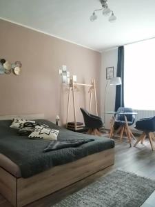 a bedroom with a bed and a table and chairs at Aréna Apartman in Kaposvár