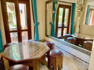um quarto com uma mesa, cadeiras e espelhos em Villa Agdal em Marrakech
