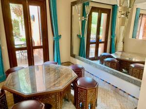 a room with a table and chairs and mirrors at Villa Agdal in Marrakesh