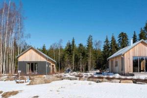 dos casas en la nieve con árboles en el fondo en Villa Nyman, en Jakobstad