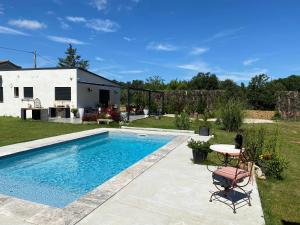 een achtertuin met een zwembad en een huis bij Le Galinié Chic'Art. Un bel Atelier avec Piscine in Carpentras