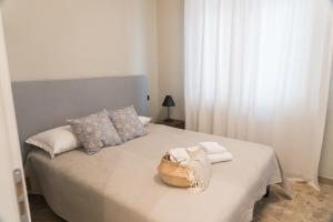 a bedroom with a bed with towels and a basket on it at Arena Rooms in Verona