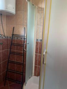 y baño con ducha y puerta de cristal. en Elit Tuzla en Tuzla