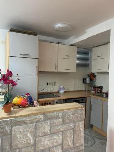 uma cozinha com armários brancos e uma bancada em Elit Tuzla em Tuzla