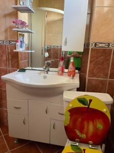 ein Badezimmer mit einem Waschbecken und einem WC mit einem Apfel darauf in der Unterkunft Elit Tuzla in Tuzla
