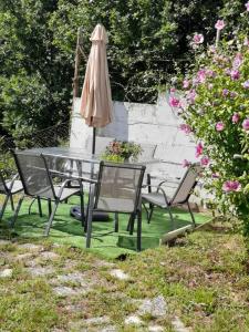a table and chairs with an umbrella and flowers at Piso con preciosas vistas de vigo in Vigo