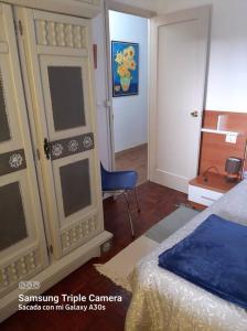 a bedroom with a bed and a door and a chair at Piso con preciosas vistas de vigo in Vigo