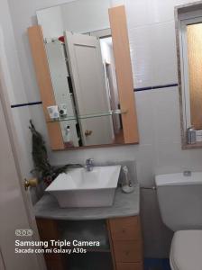 a bathroom with a sink and a mirror and a toilet at Piso con preciosas vistas de vigo in Vigo