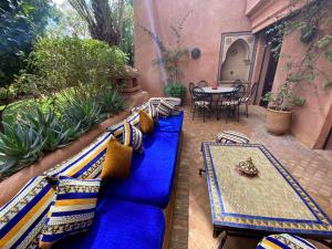 eine blaue Couch mit Kissen auf einer Terrasse in der Unterkunft Villa Agdal in Marrakesch