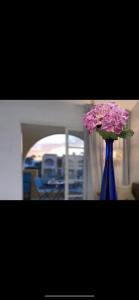 Un jarrón azul con flores rosas. en Tisalaya Bright Apartment en Maspalomas
