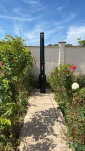 a black pole in the middle of a walkway at Guest House Golden Flake 4km from Bolata beach in Bŭlgarevo