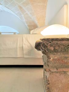 1 dormitorio con 1 cama y 1 mesa con lámpara en LE DIMORE CENTRO en Gallipoli