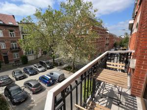 einen Balkon mit Blick auf einen Parkplatz mit geparkten Autos in der Unterkunft Cozy, comfortable apt, well located - EU ULB VUB in Brüssel