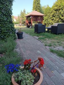 a brick walkway with flowers and a gazebo at 117 in Łeba